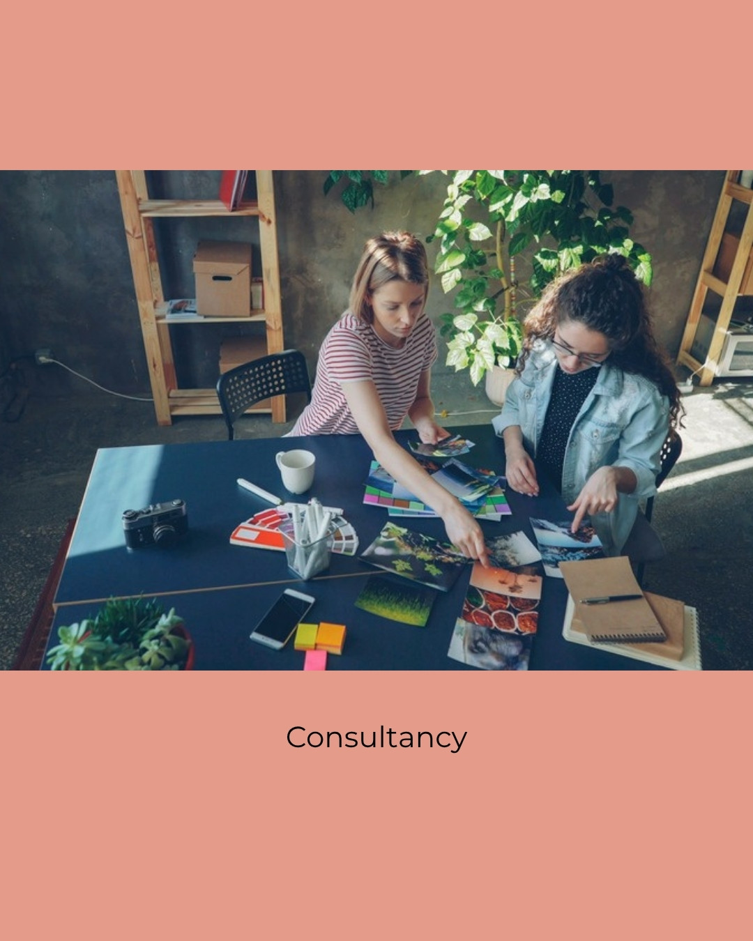 Two people in a calm conversation over coffee and notes. Caption: Consultancy.