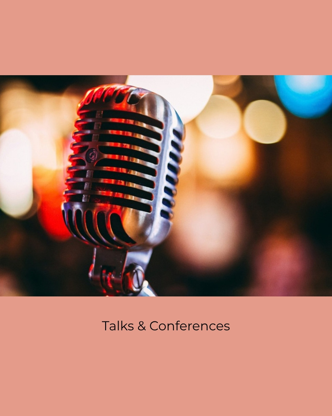 A microphone on a stand in front of a softly lit stage. Caption: Talks and Conferences.