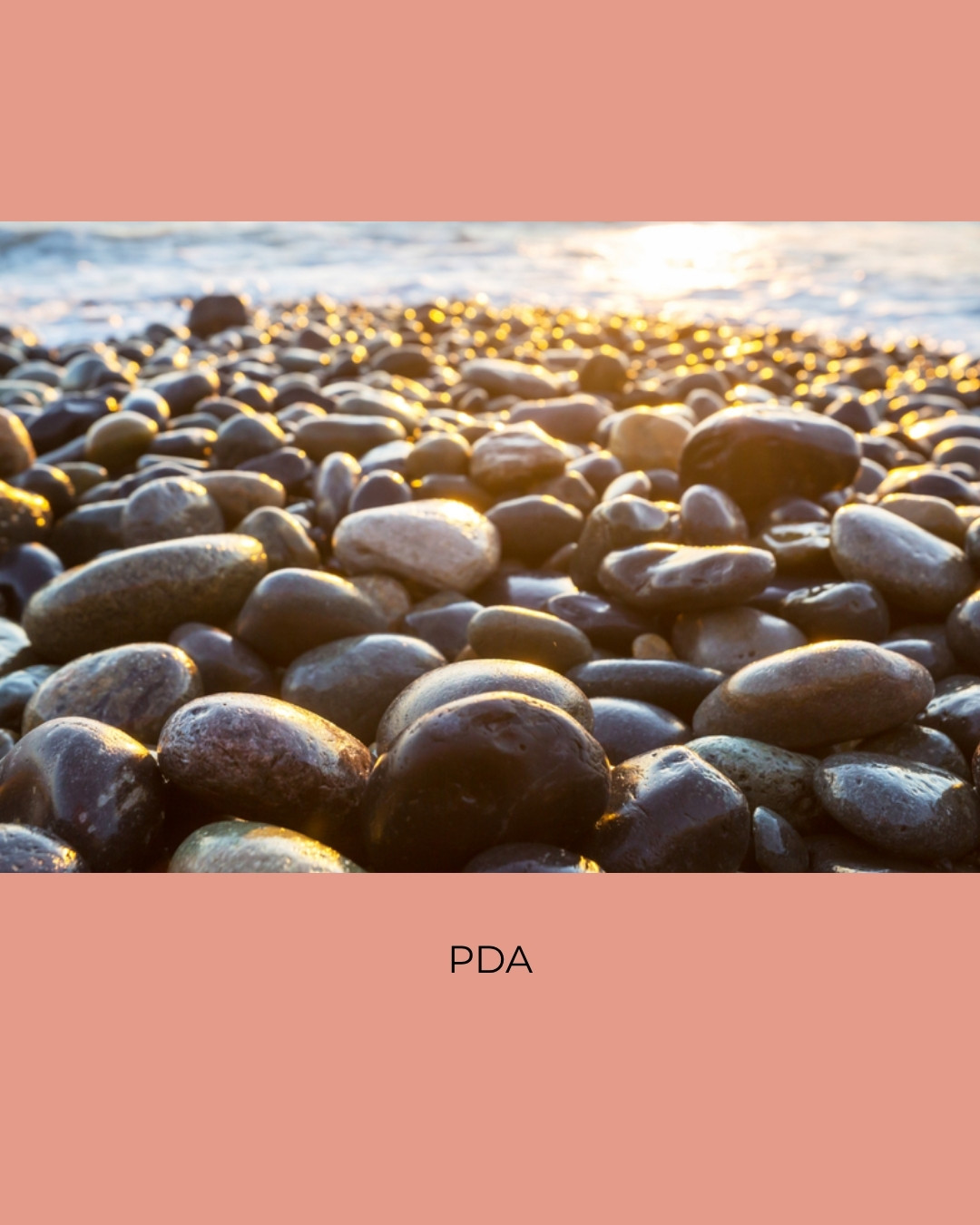 Smooth dark pebbles on a shore glowing in low sunlight. Caption: PDA.