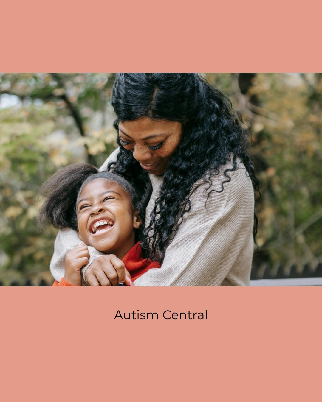 A mother hugs her laughing daughter outdoors. Caption: Autism Central.
