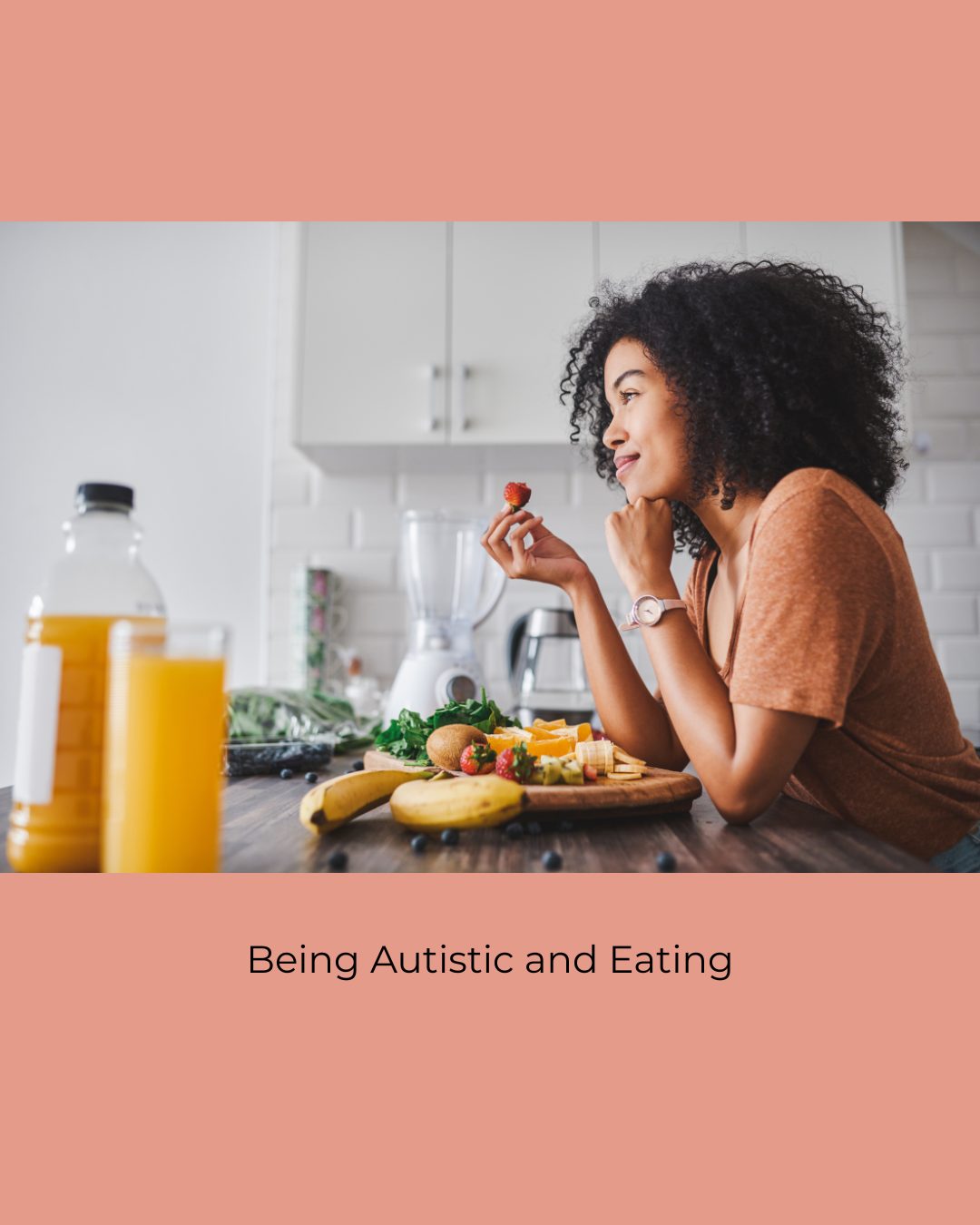 A woman with curly hair smiles as she eats a strawberry at a kitchen counter with a board of fruit and orange juice. Caption: Being Autistic and Eating.